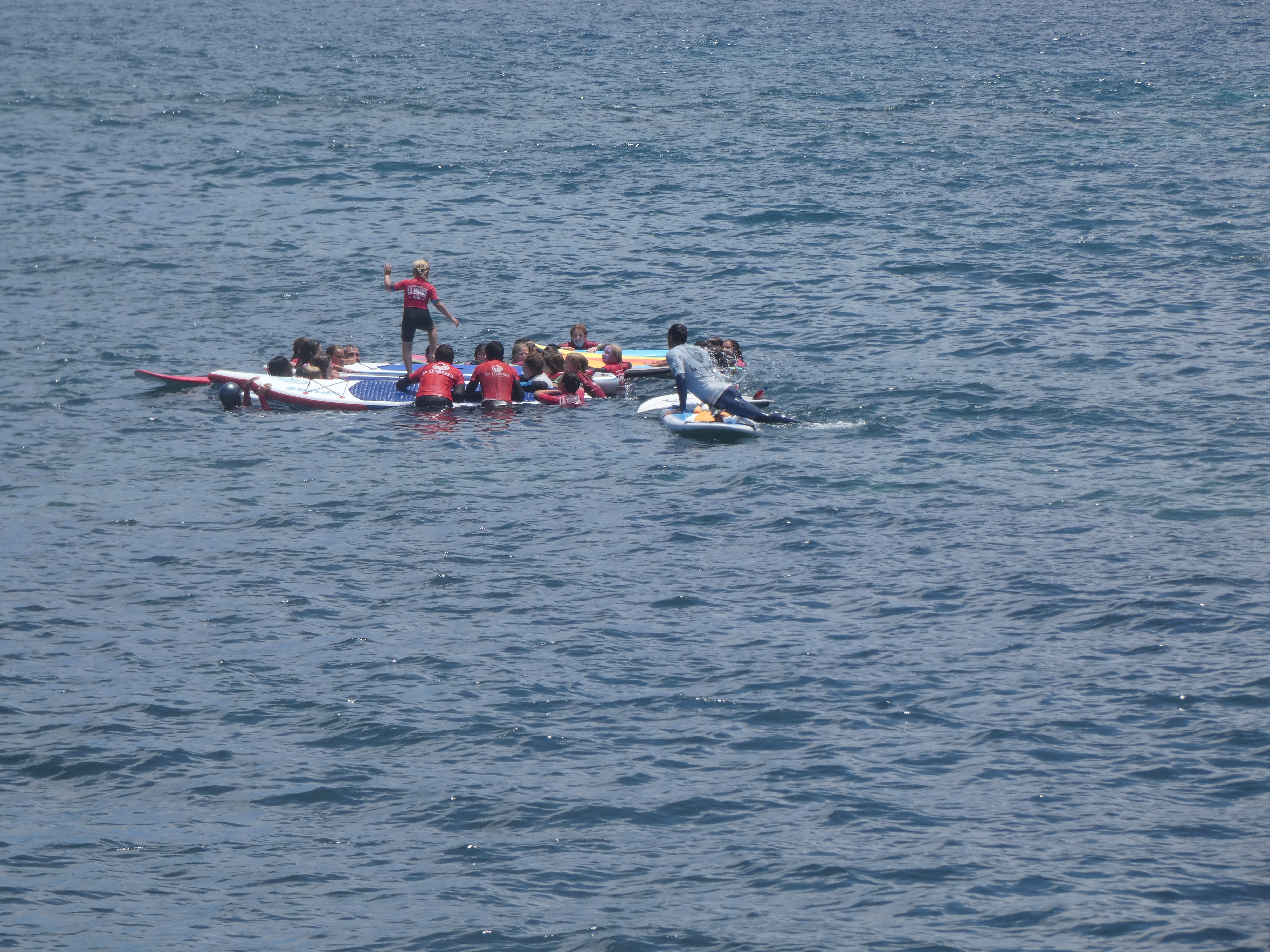 Alumnos en el mar surfando